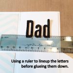 Using a ruler to line up the letters before gluing them down
